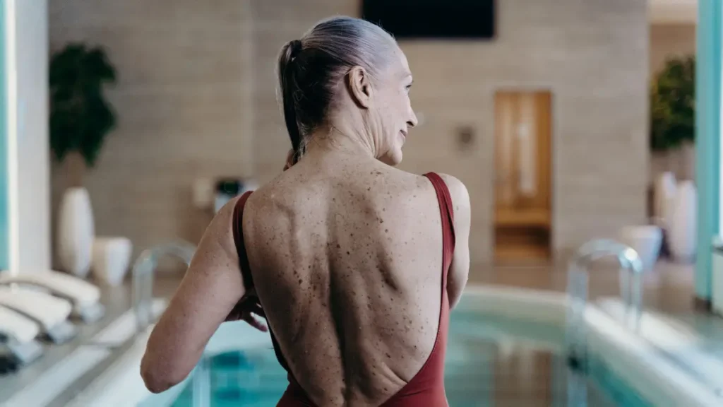 Mujer madura activa y saludable junto a una piscina, reflejando los beneficios del ayuno intermitente en la etapa de la menopausia