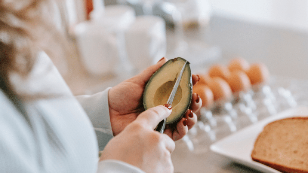 Preparación de aguacate, huevos y pan integral para un desayuno equilibrado