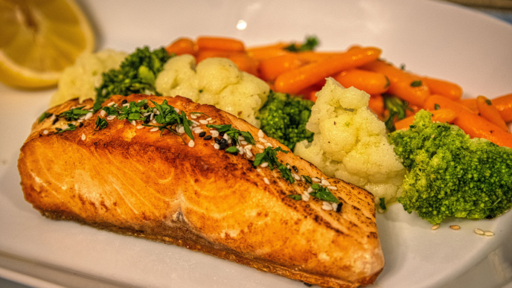 Plato de salmón a la plancha con verduras frescas y limón