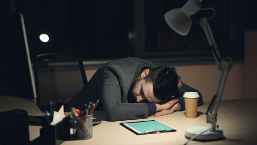 Hombre de negocios cansado en su computadora portátil por la noche