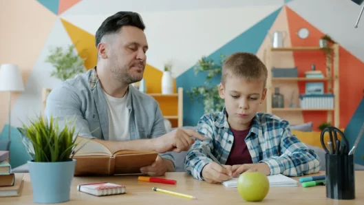Niño haciendo la tarea con la orientación de sus padres
