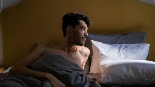 Persona despertando con la luz de la mañana en el dormitorio