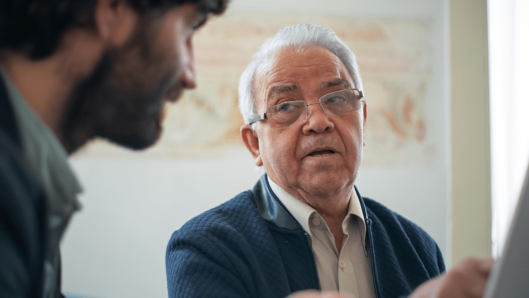 Persona mayor con audífono en conversación