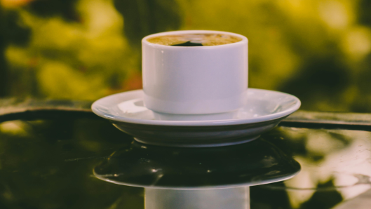 Taza de café en primer plano, luz cálida de la mañana.